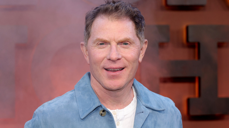 Food Network star and chef Bobby Flay in blue jacket and white button-up shirt smiling at camera
