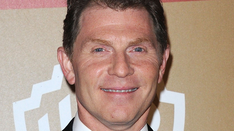 Bobby Flay smiles in a suit