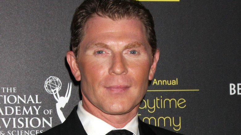 Bobby Flay smiles in suit and tie