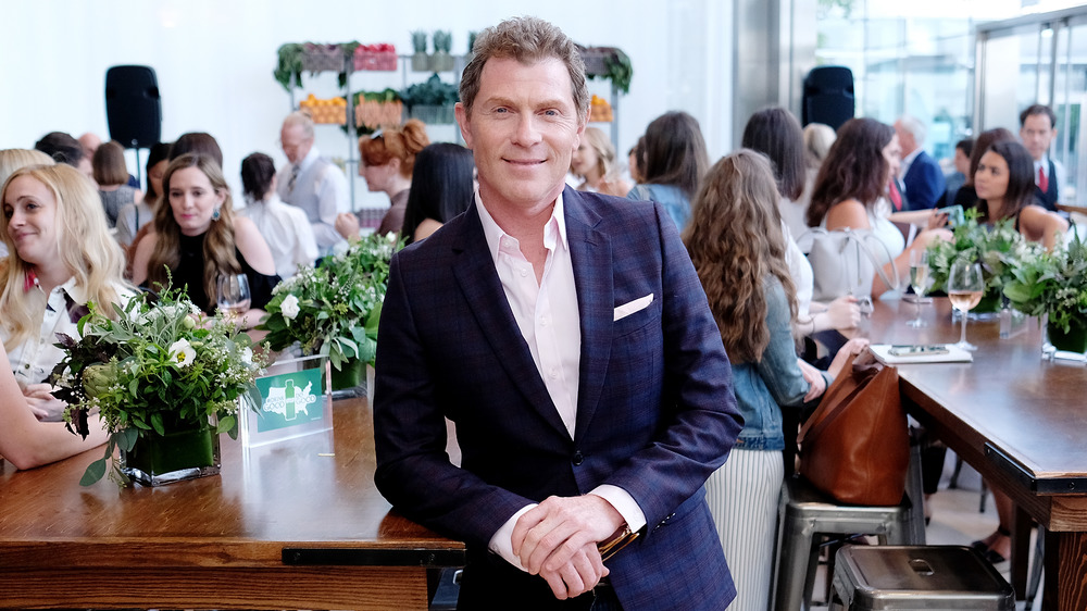 bobby flay leaning on wooden counter