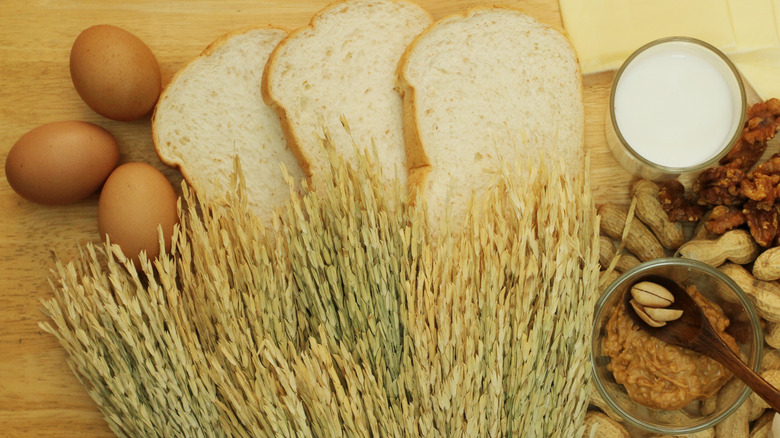 Bread, eggs, wheat stalks, and nuts on wood table