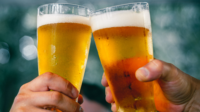 two hands cheersing glasses of beers