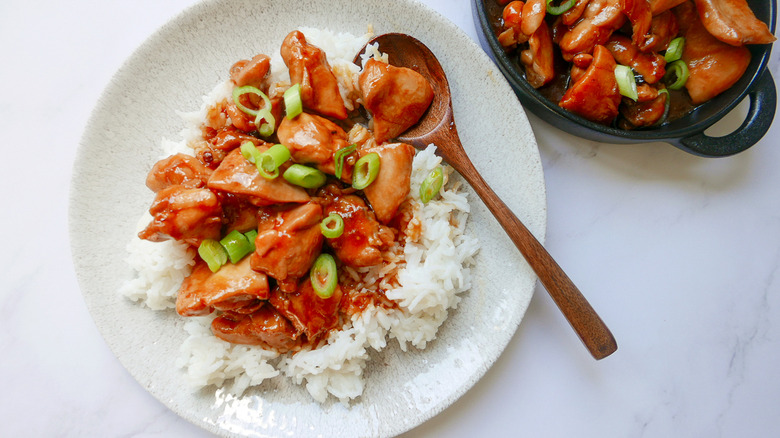 spooning chicken over rice