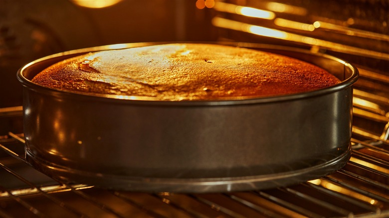 A golden-brown cake baking in the oven
