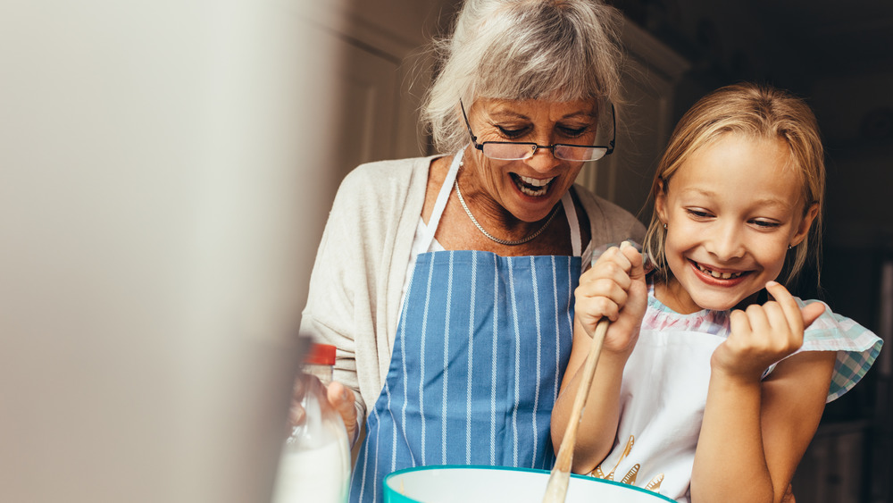 grandma and girl baking a cake