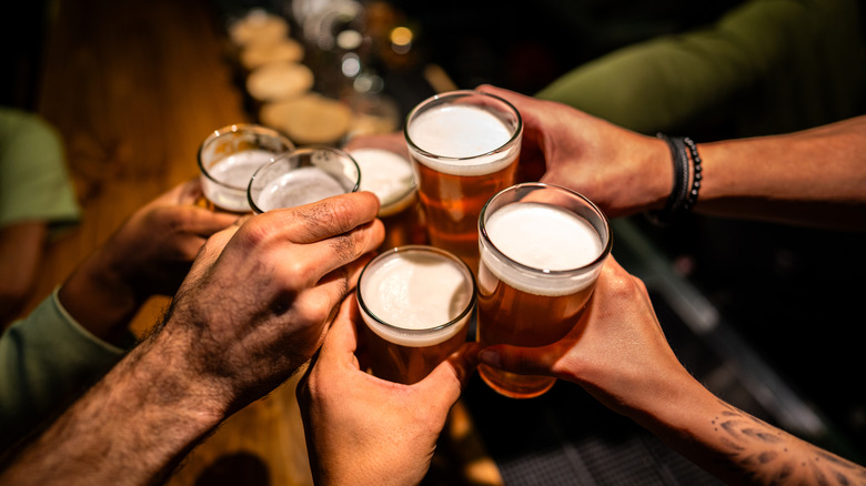 Hands clinking glasses of beer together