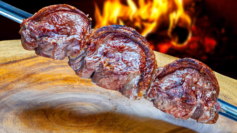 Cuts of picanha, fresh off the flame on a skewer.