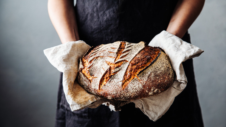 Holding loaf of bread