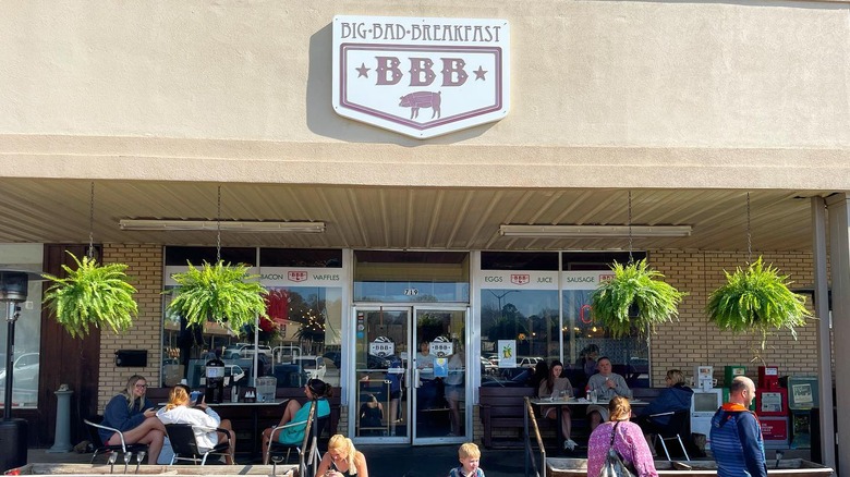 Exterior entrance at Big Bad Breakfast in Oxford with outdoor seating area under ferns in hanging pots