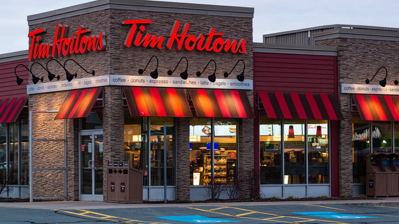 tim hortons exterior restaurant entrance with sign lit up