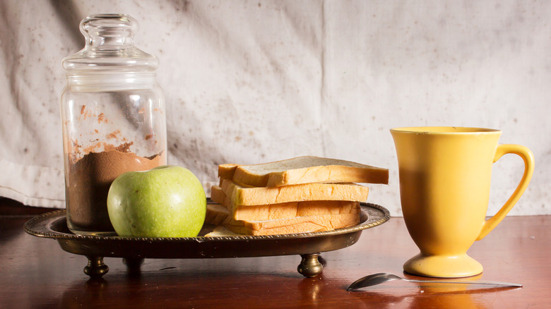 Vintage photo of cocoa, apple, bread, and coffee mug