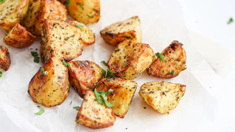 A plate of roasted potatoes with herbs