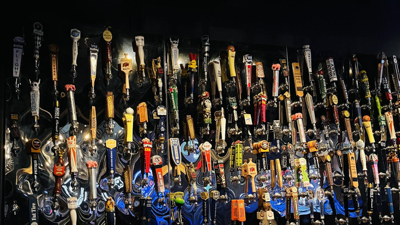 Beer tap area with dozens of draft beer selections on display