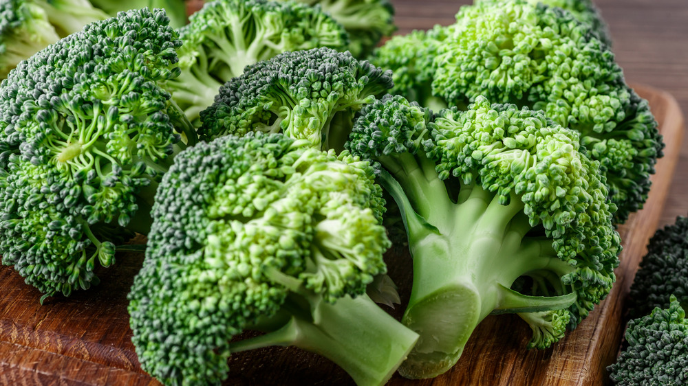 broccoli florets on wood cutting board