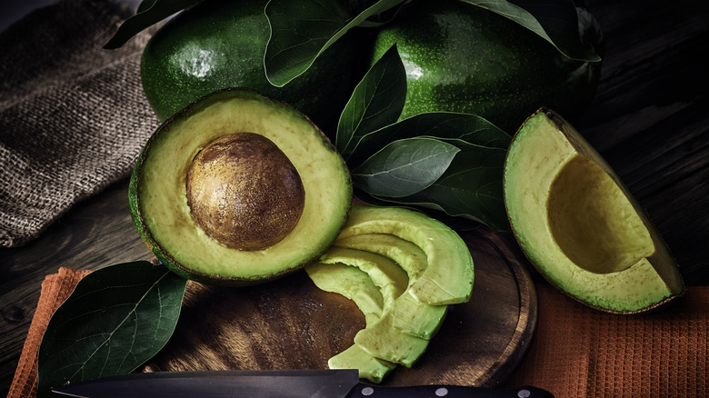 An avocado cut in sections with slight marks of brown on the green flesh.