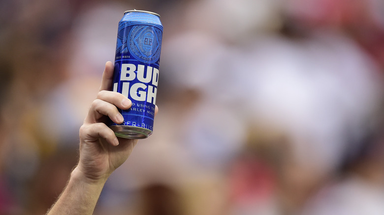 person holding up blue Bud Light can