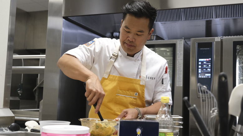 Buddha Lo mixing ingredients in kitchen