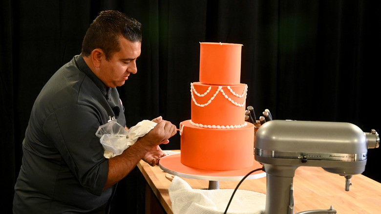 Buddy Valastro decorating an orange cake