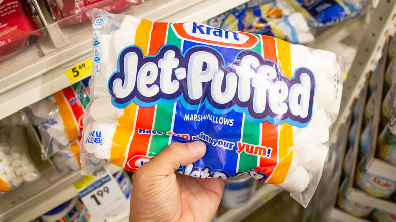 Person holding jet puffed marshmallows in store