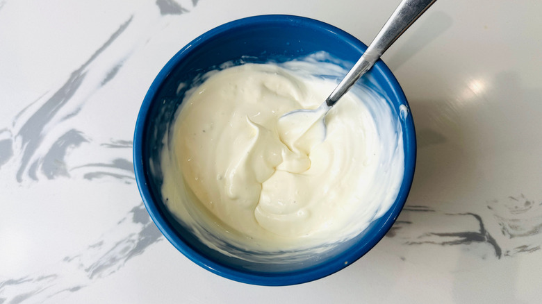 Mayonnaise and sour cream mixed in bowl