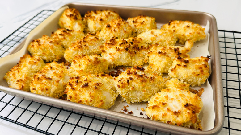 Baked chicken pieces on baking sheet
