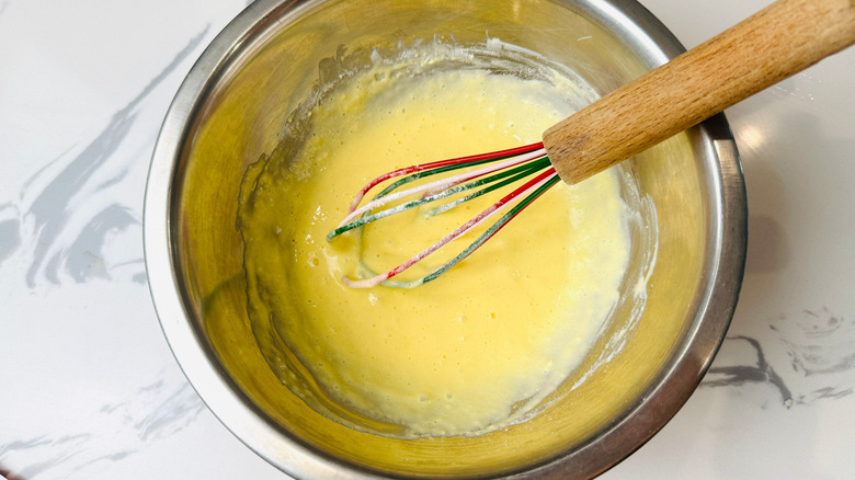 Egg mixture in bowl with whisk