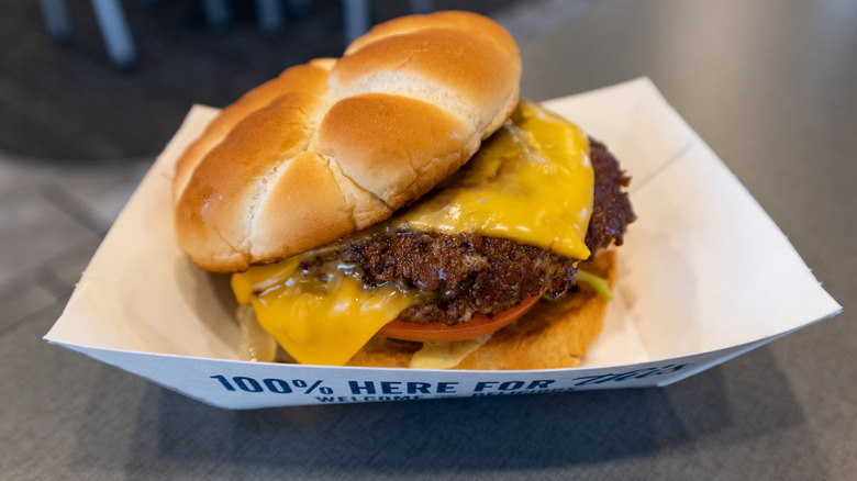 Culver's double cheeseburger in paper boat on table inside restaurant