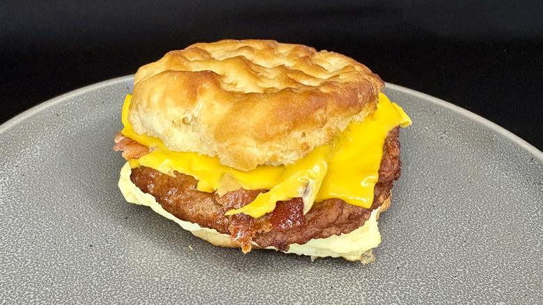 Bacon, sausage, egg, and cheese biscuit sandwich on gray plate