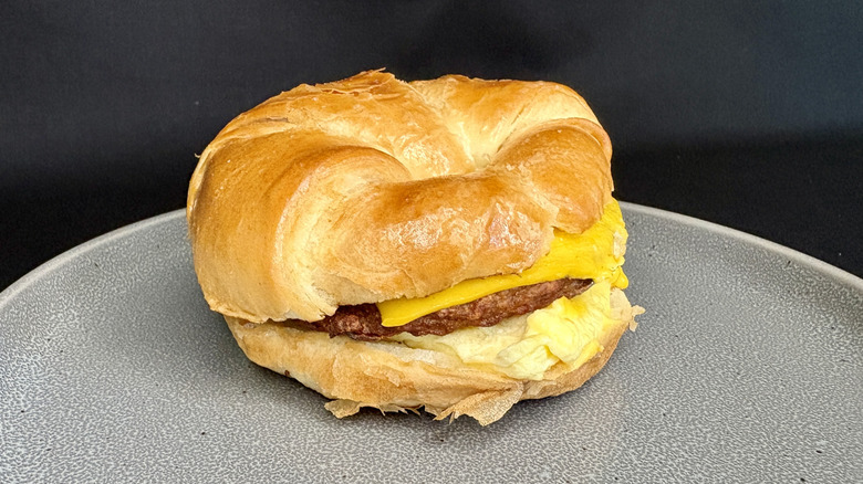 Sausage, egg, and cheese croissant sandwich on gray plate