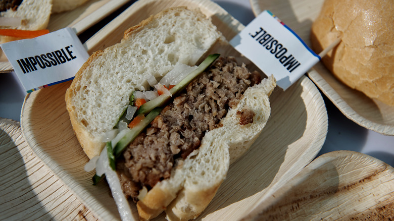 Impossible burger cut down the middle on wood plate