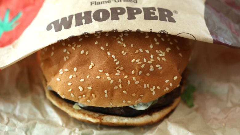 A Whopper from Burger King tucked inside a paper wrapper