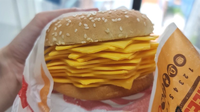 person holding burger king thailand real cheese burger