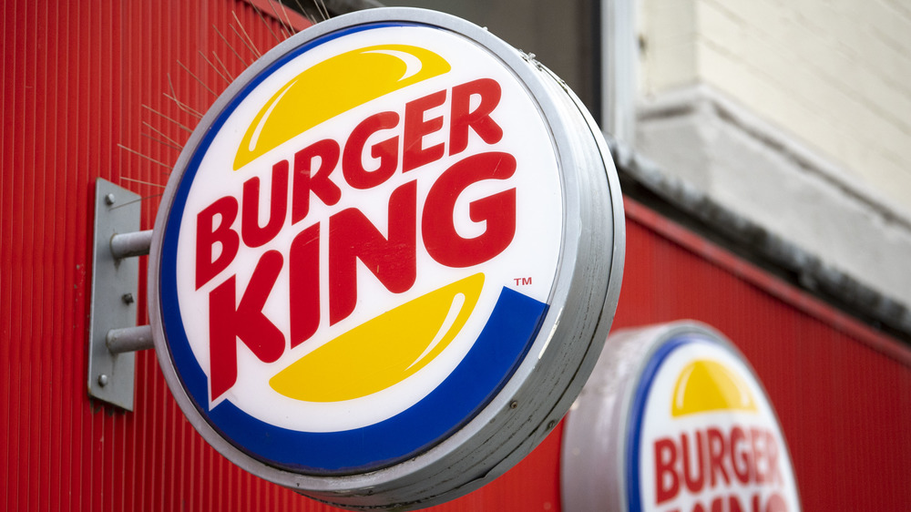 Round Burger King sign protruding from side of building, with round BK sign in background
