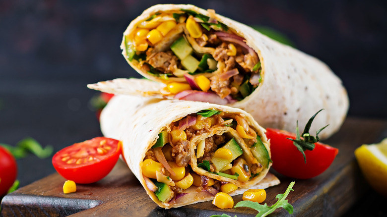 Burritos with beef and vegetables on a dark background