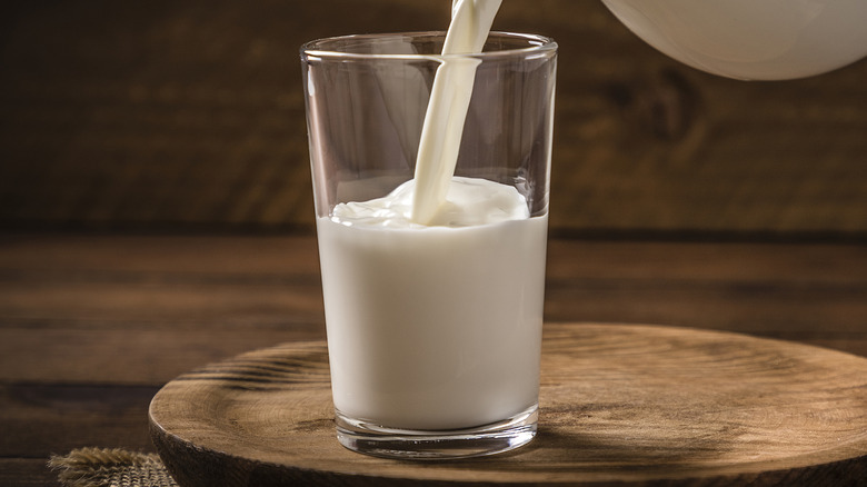 Milk poured in glass from pitcher
