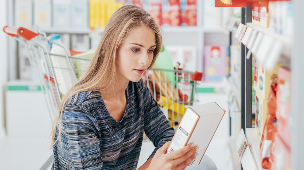 women reading packaged food label