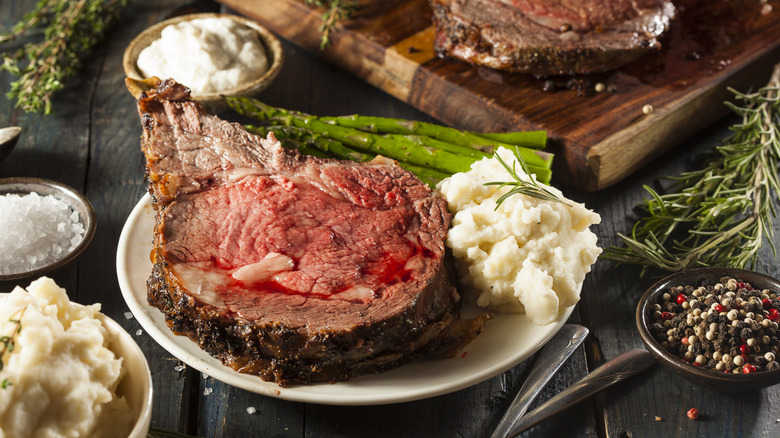 Prime rib on plate with mashed potatoes and asparagus