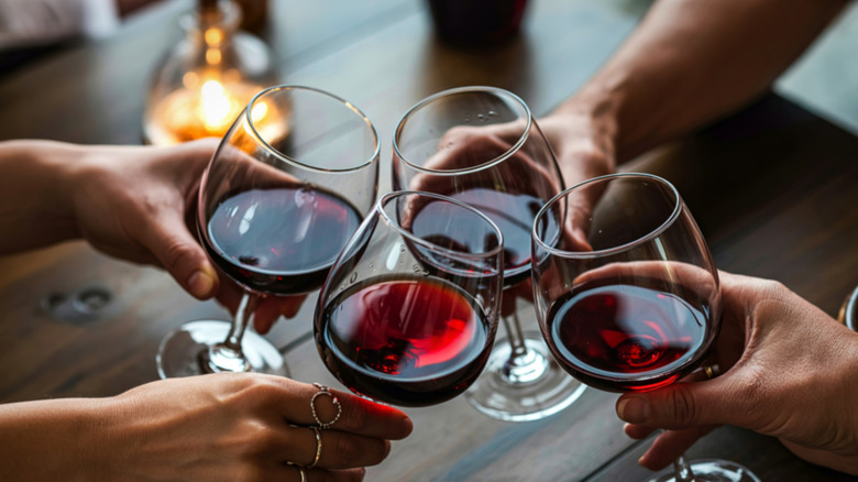 Four wine glasses held together for a toast