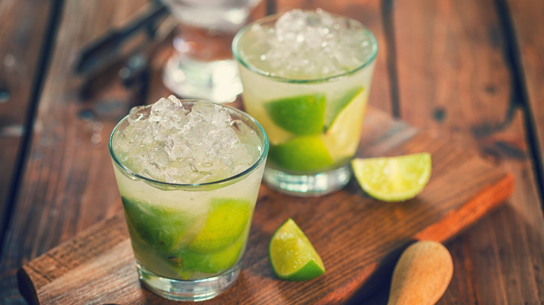 Two caipirinhas on a board.