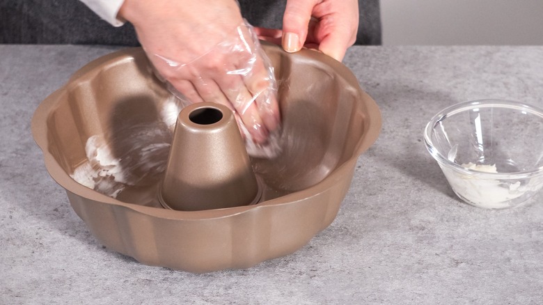 Baker greasing a bundt pan