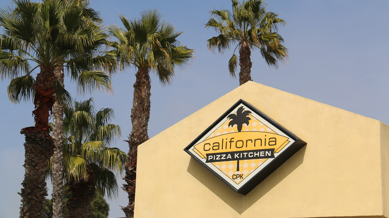 California pizza kitchen restaurant with palm trees in background