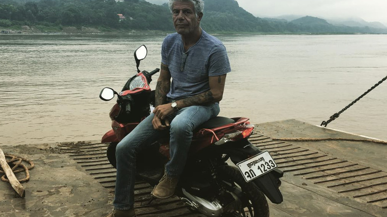 Anthony Bourdain on motorbike at the waterside