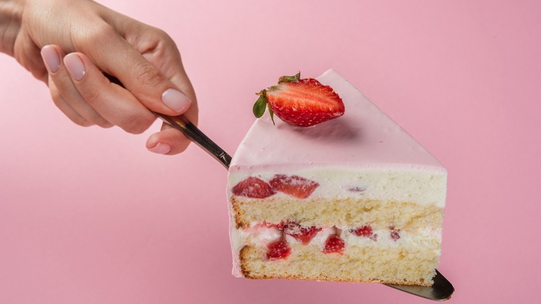 person holding slice of cake