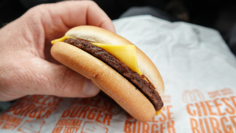 Man eating McDonald's cheeseburger