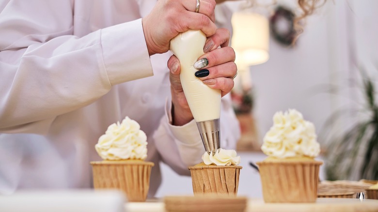 Chef puts icing on a cake