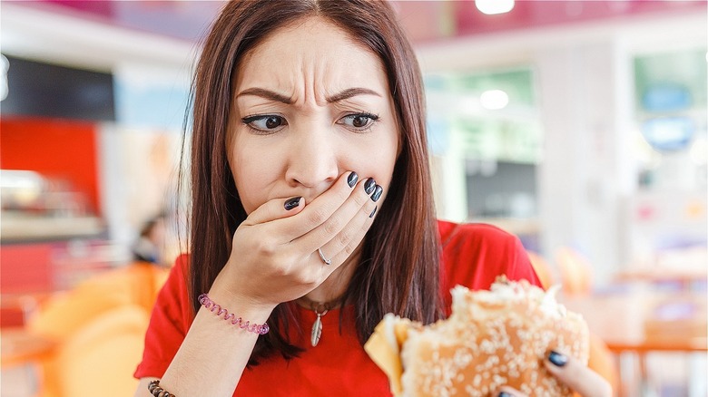 Woman biting into burger with hair