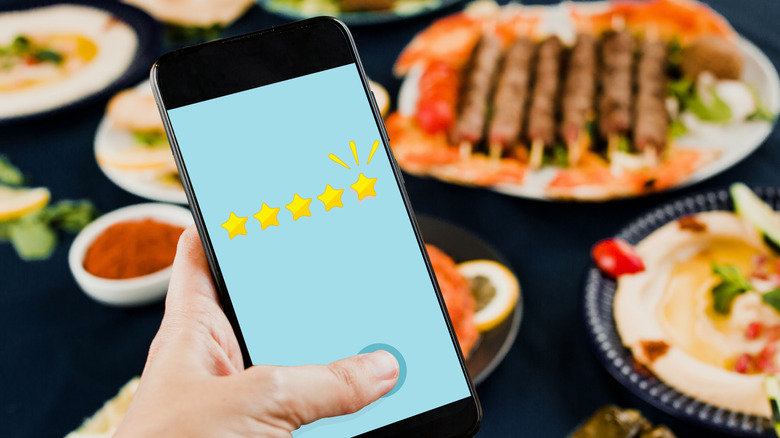 Person giving 5-star rating to meal on phone app