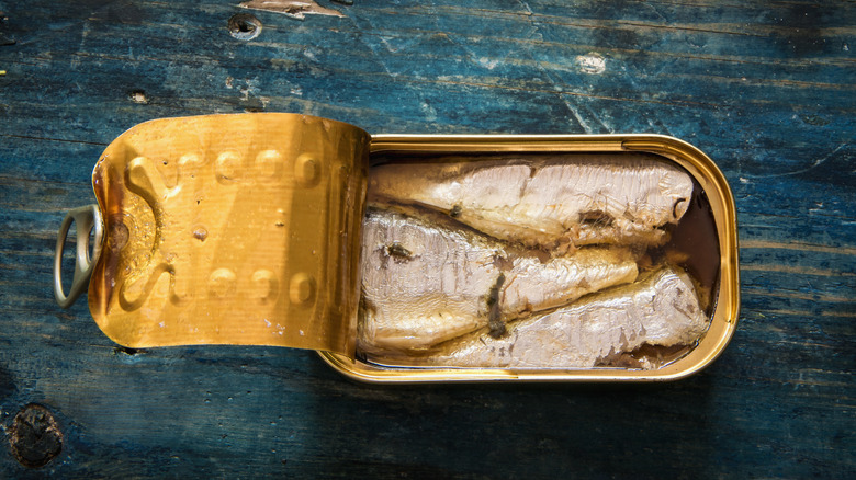 Tinned herring on blue wood
