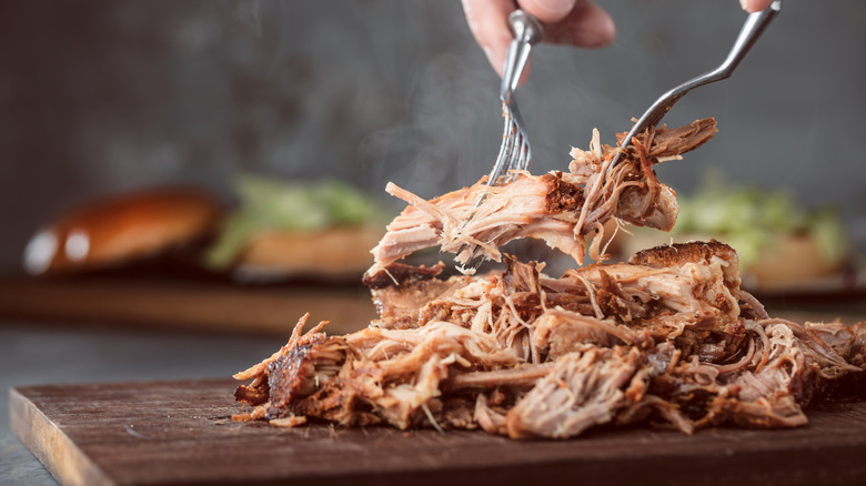 someone shredding pork with two forks