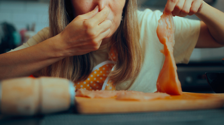 A woman reacting to the smell of spoiled meat